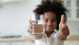 child holding a glass of water